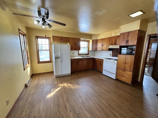 kitchen featuring sink, white appliances, ceiling fan, dark hardwood / wood-style floors, and a baseboard radiator