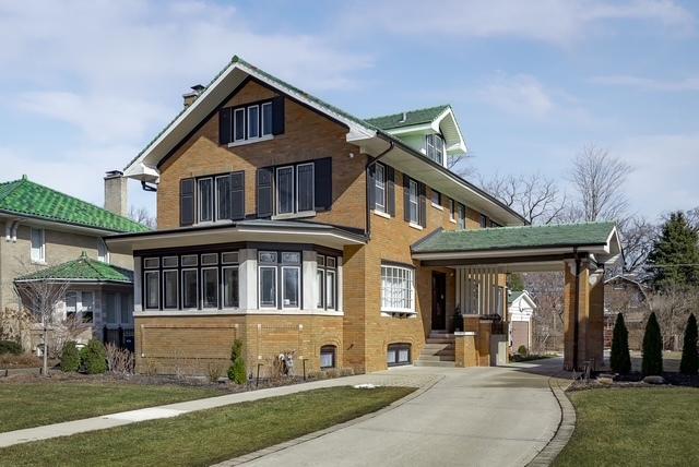 view of front facade featuring brick siding, driveway, and a front lawn