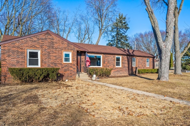 ranch-style house featuring brick siding and a front yard