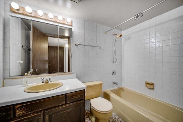 bathroom with toilet, vanity, tile walls, and shower / bathing tub combination