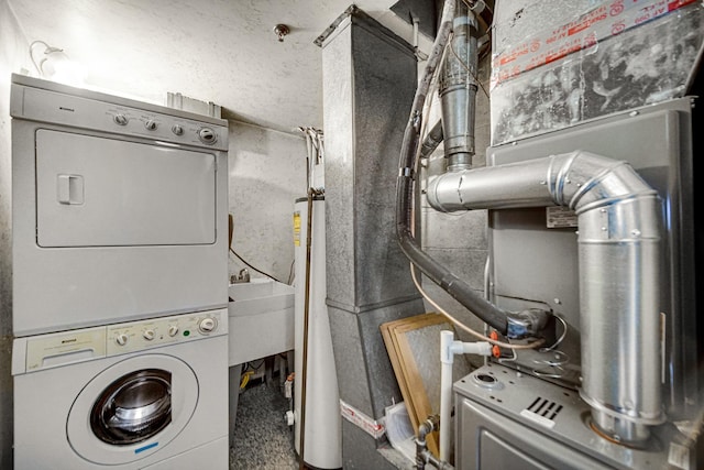 washroom with laundry area, a sink, and stacked washing maching and dryer