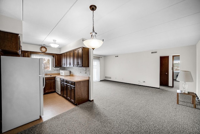 kitchen featuring white appliances, plenty of natural light, and dark brown cabinets