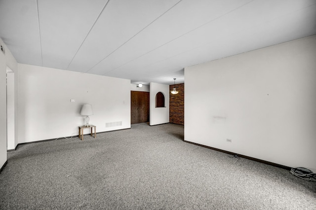 carpeted spare room with visible vents and baseboards