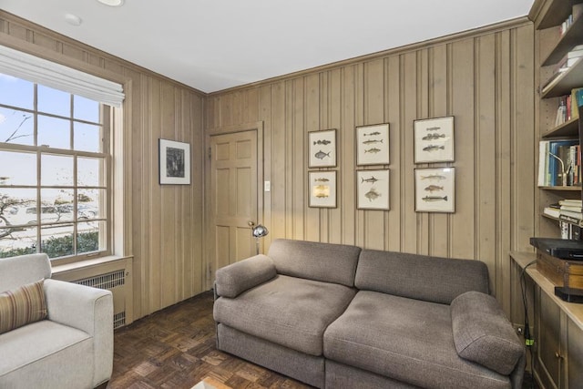 living room featuring radiator and wood walls