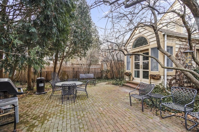 view of patio featuring outdoor dining area, a grill, and fence