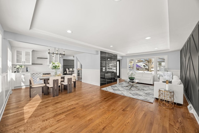 living room featuring a tray ceiling and light hardwood / wood-style flooring