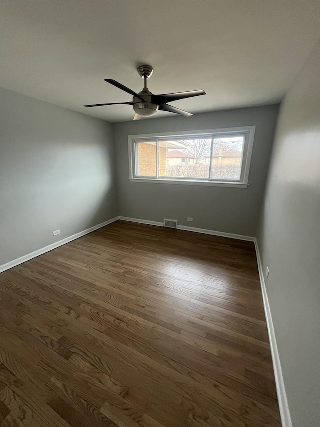 empty room with dark hardwood / wood-style flooring and ceiling fan