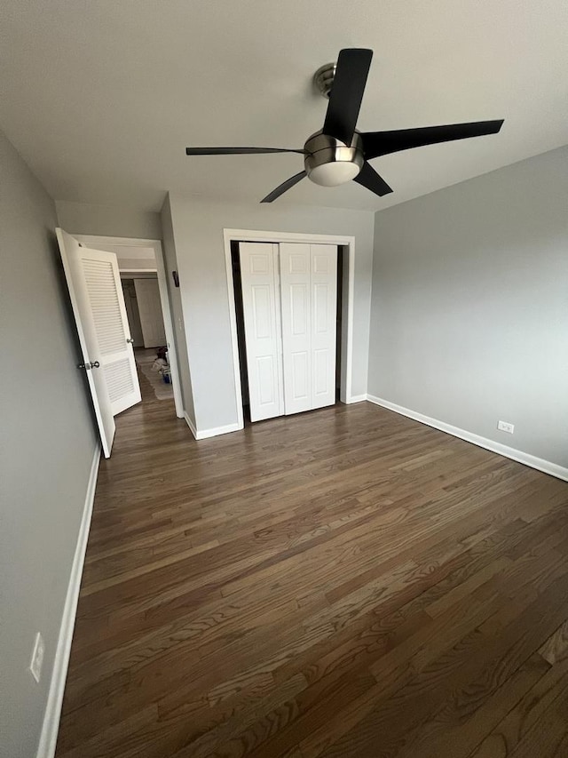 unfurnished bedroom with ceiling fan, dark hardwood / wood-style floors, and a closet