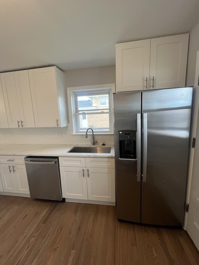 kitchen featuring dark hardwood / wood-style floors, sink, backsplash, white cabinets, and stainless steel appliances