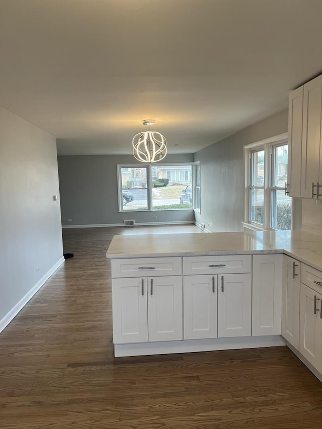 kitchen featuring a chandelier, hanging light fixtures, dark hardwood / wood-style flooring, kitchen peninsula, and white cabinets