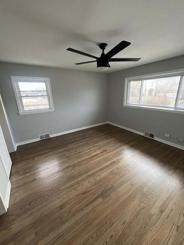 spare room with dark wood-type flooring and ceiling fan