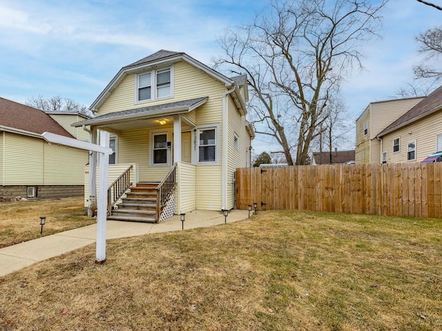 bungalow-style house with a front yard and covered porch