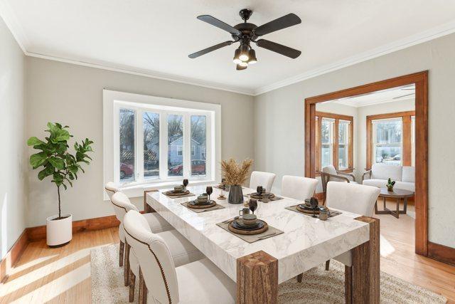 dining area with ornamental molding, light wood-style flooring, and baseboards