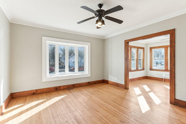 spare room featuring a healthy amount of sunlight, light wood-style flooring, and ornamental molding