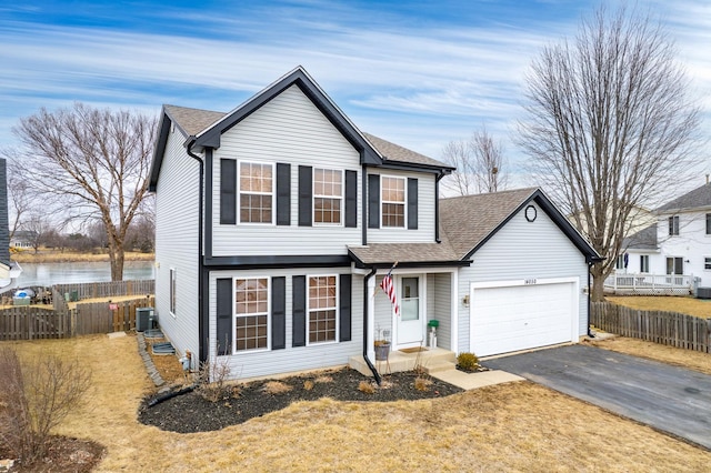 view of front of home with a garage, a water view, and central AC