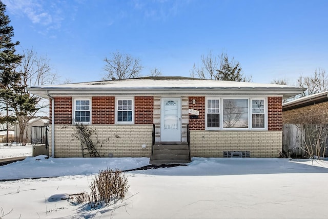 bungalow-style home featuring entry steps, brick siding, and fence