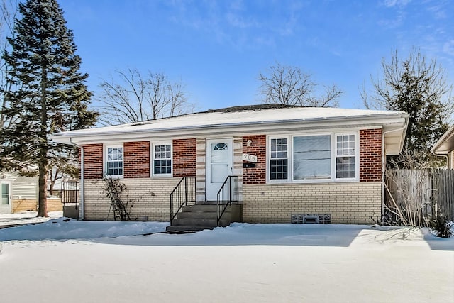 view of front of property with brick siding and fence