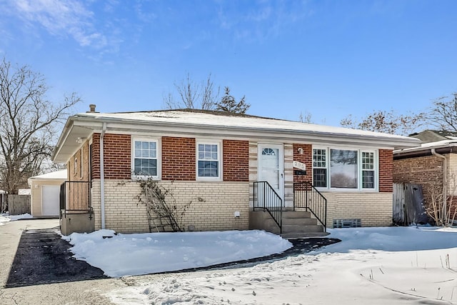 bungalow-style home with a detached garage and brick siding