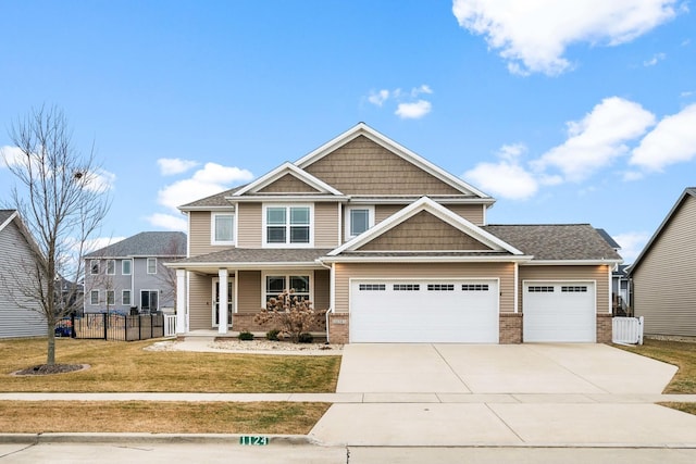 craftsman house with a garage, covered porch, and a front lawn