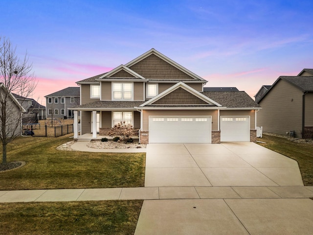 craftsman house featuring a garage and a lawn