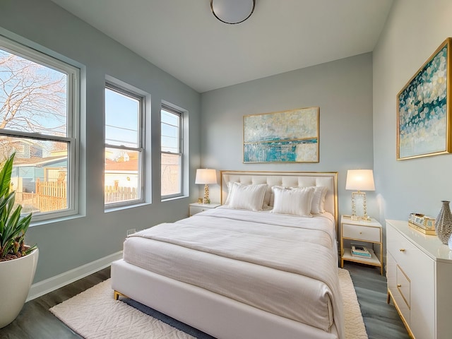 bedroom featuring baseboards and dark wood-style flooring