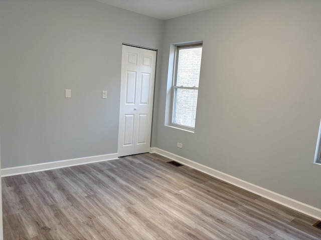 unfurnished room with visible vents, baseboards, and light wood-style flooring