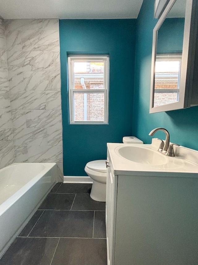 bathroom with baseboards, plenty of natural light, vanity, and toilet