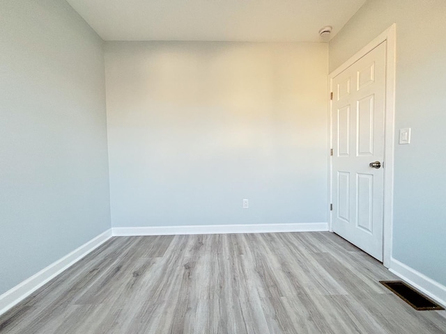 unfurnished room featuring light wood-style floors, baseboards, and visible vents