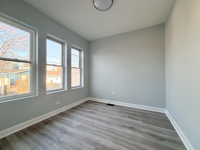 spare room featuring baseboards and wood finished floors