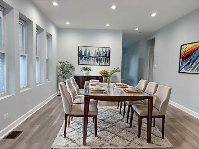 dining space with baseboards, visible vents, wood finished floors, and recessed lighting