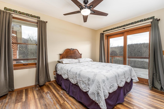 bedroom with multiple windows, dark hardwood / wood-style floors, and ceiling fan