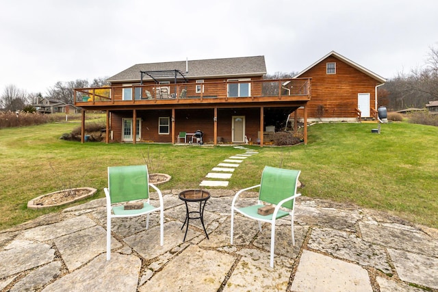 rear view of house with a patio, a lawn, a deck, and a fire pit