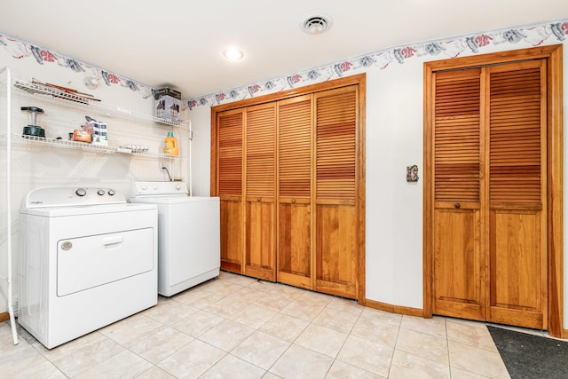 laundry area with washer and dryer and light tile patterned floors