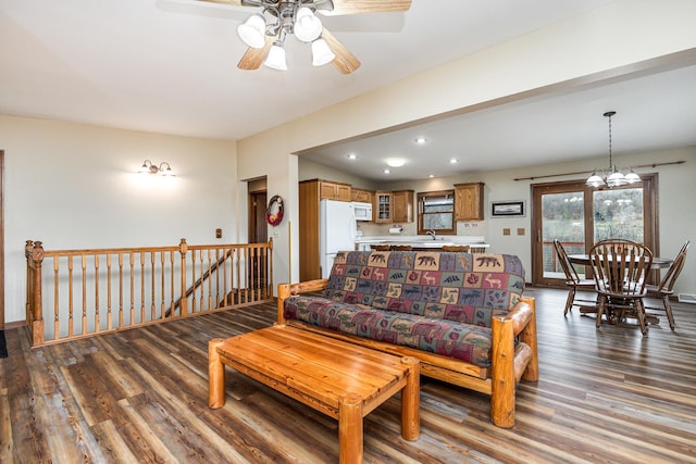 living room featuring ceiling fan with notable chandelier, sink, and hardwood / wood-style floors