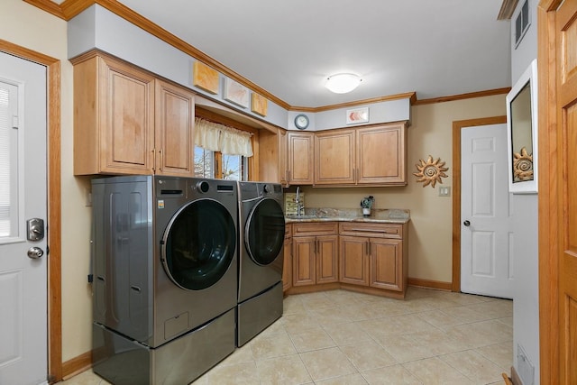 clothes washing area with sink, light tile patterned floors, crown molding, cabinets, and washing machine and clothes dryer