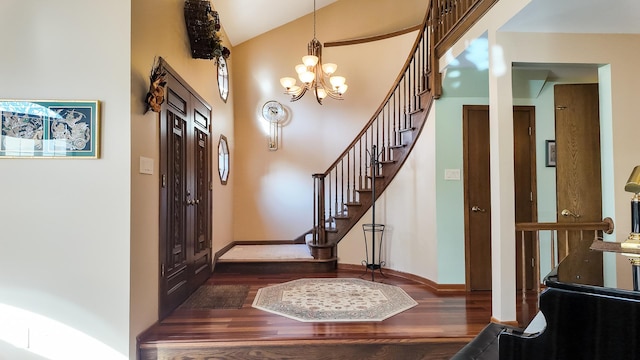 foyer entrance with a towering ceiling, a notable chandelier, and dark hardwood / wood-style flooring