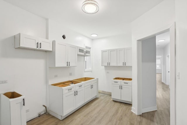 kitchen with white cabinetry and light hardwood / wood-style flooring