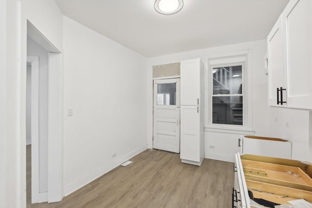 kitchen featuring light hardwood / wood-style flooring and white cabinets