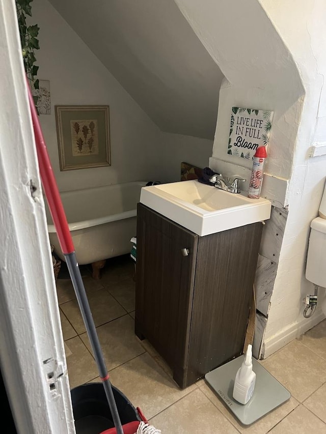 bathroom with lofted ceiling, vanity, and tile patterned flooring