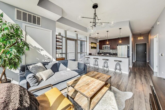 living room featuring sink, a chandelier, and dark hardwood / wood-style flooring