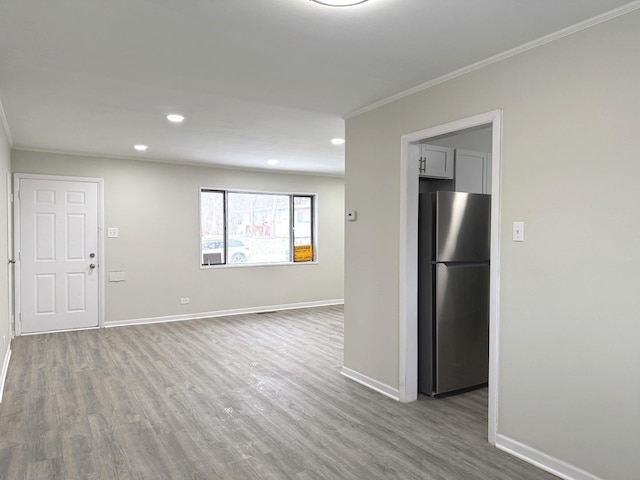 empty room featuring hardwood / wood-style flooring and ornamental molding