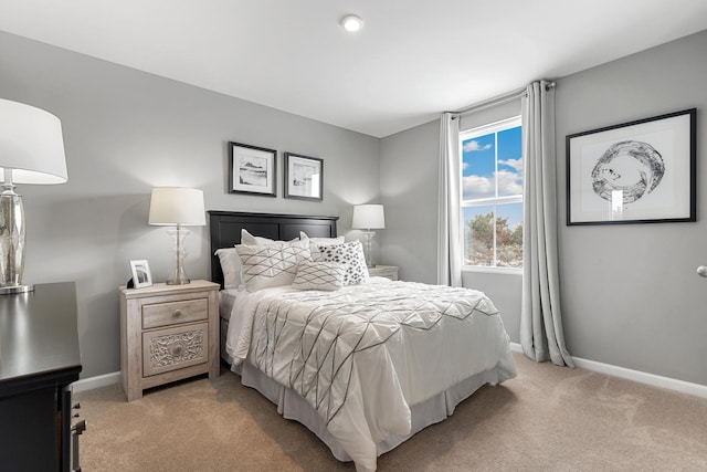 bedroom featuring light carpet and baseboards