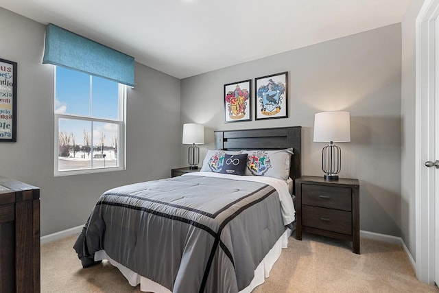 bedroom with baseboards and light colored carpet