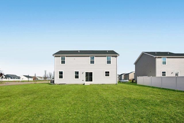 back of house featuring a yard and fence