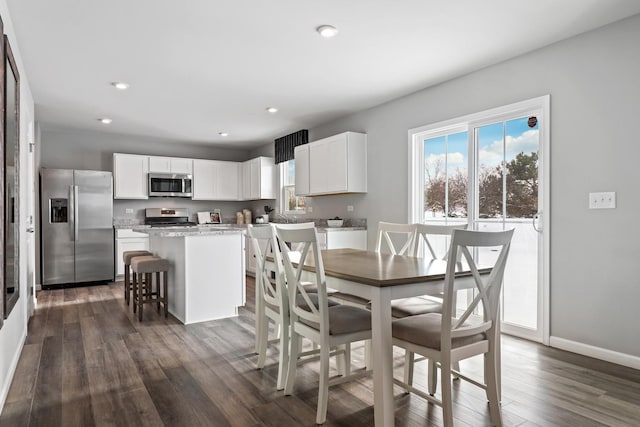 dining space featuring baseboards, dark wood-type flooring, and recessed lighting