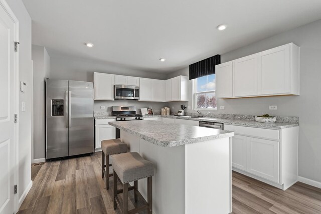 kitchen with light wood-type flooring, appliances with stainless steel finishes, and light countertops