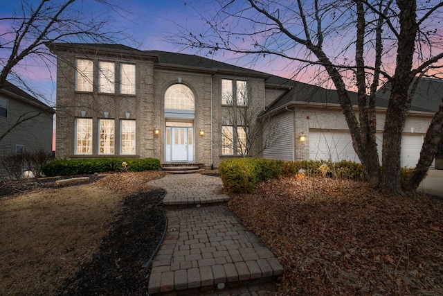 view of front of home with brick siding, entry steps, and a garage