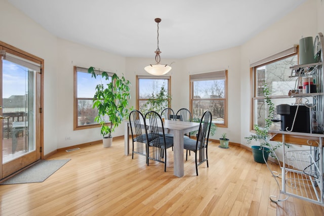 dining space featuring visible vents, light wood-style flooring, plenty of natural light, and baseboards