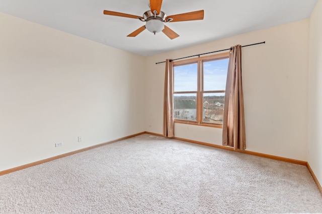 empty room with carpet flooring, baseboards, and a ceiling fan