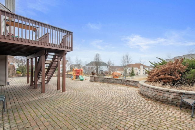 view of patio / terrace with a wooden deck, stairs, and a playground